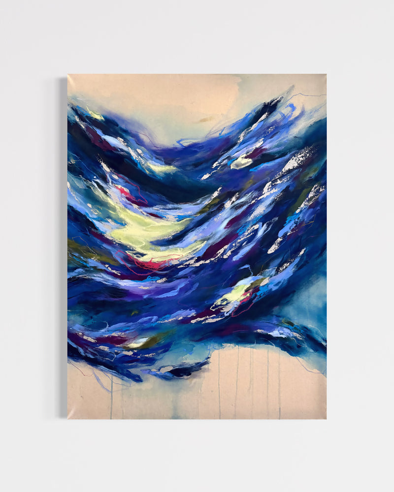 An abstract canvas painting featuring dynamic, textured brushstrokes of deep blue, navy, and white, accented with splashes of yellow, red, and purple, set against a light beige background. The painting is shown hanging on a neutral light gray wall.