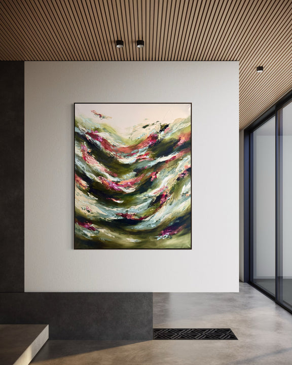 An abstract landscape painting with flowing green, beige, and pink brushstrokes, displayed in a modern interior hallway with a slatted wood ceiling and concrete floor.